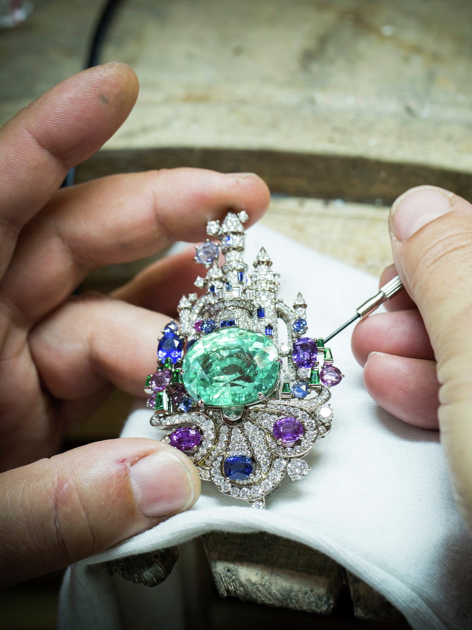 Château enchanté clip. 18K white gold, one oval-cut emerald of 39.85 carats, colored sapphires, emeralds, diamonds. Private collection.